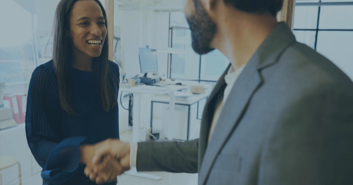 A man and woman shaking hands in the office