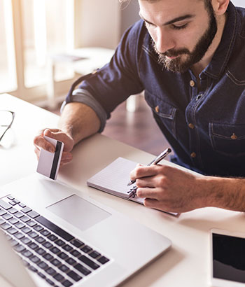 Man using a credit card at a laptop computer