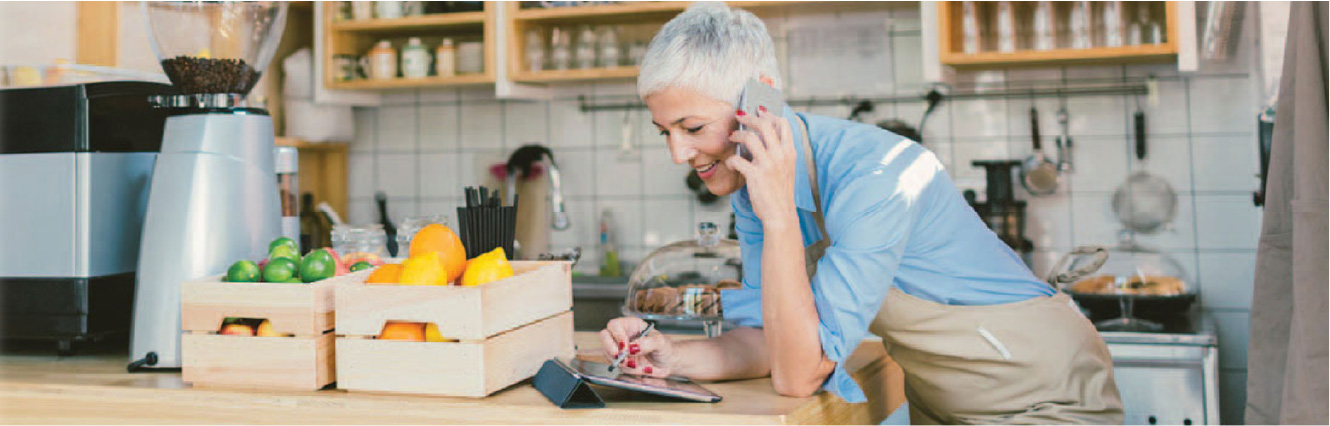 Lady in a shop on the phone while working