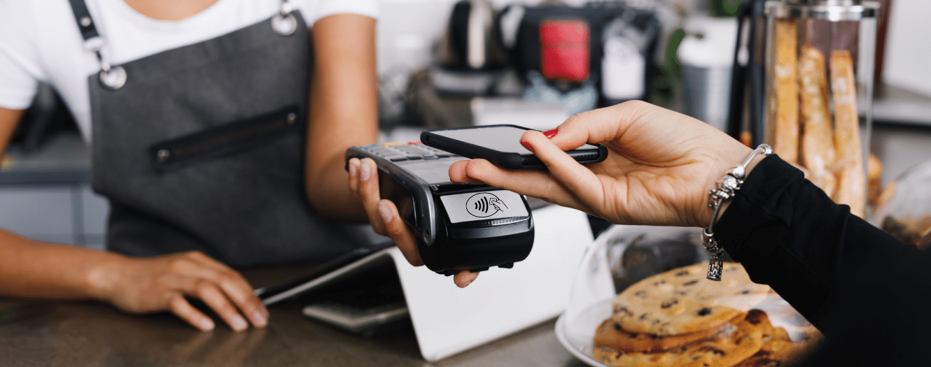 Woman paying at a merchant with mobile phone