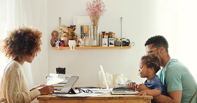 A family sitting around laptop computers