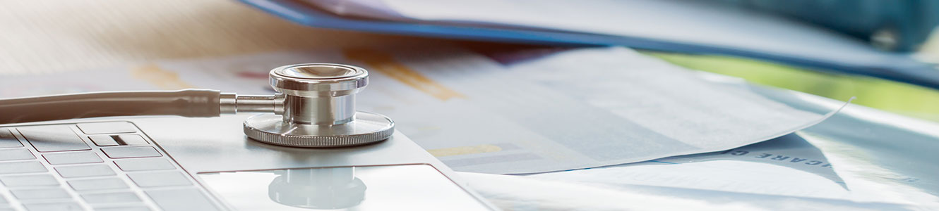 Stethoscope on a desk with papers