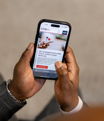 Holding a cell phone with CNB website