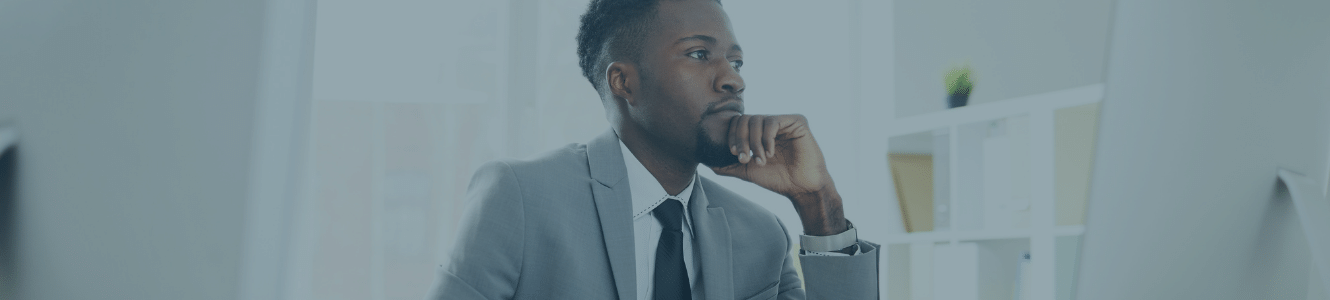 Man thinking and looking at his computer while he is in the office