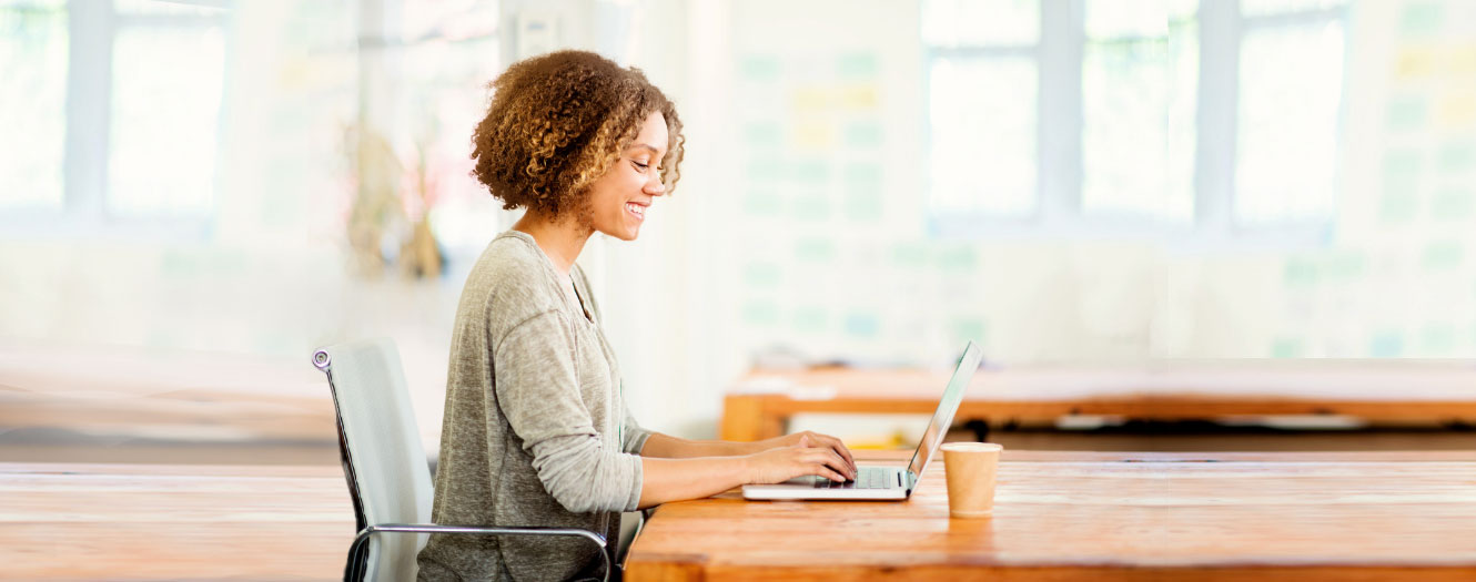 Business woman on laptop searching for ways to prevent business check fraud